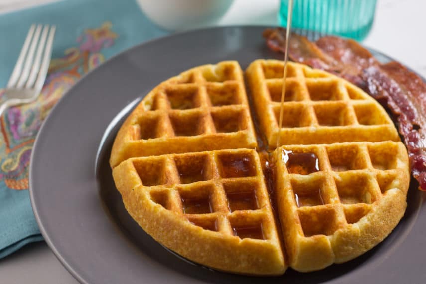 Maple syrup being poured on top of a low FODMAP cornbread waffle. 
