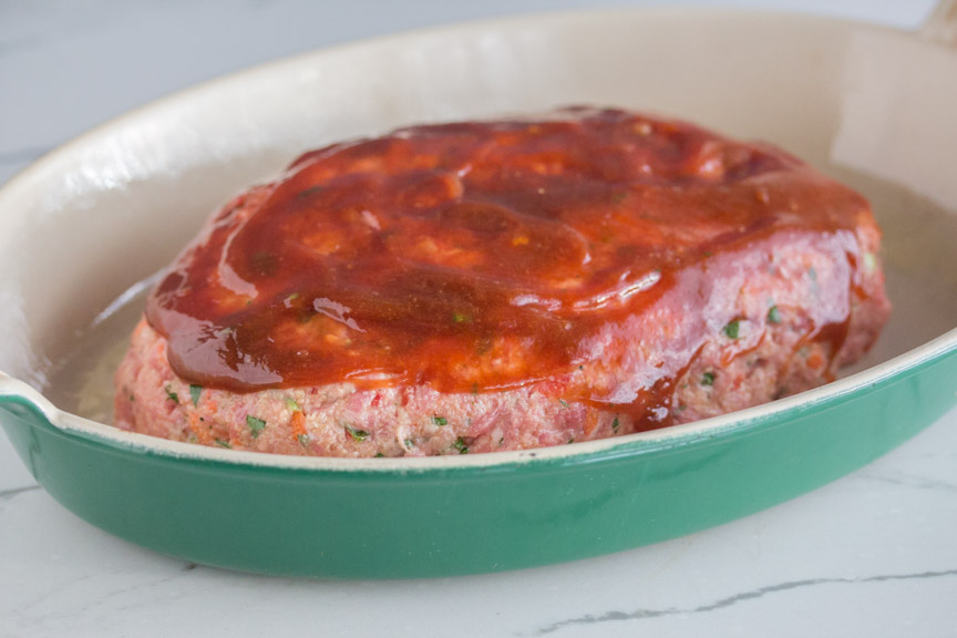 Low FODMAP Everyday Meatloaf slathered in sauce before baking. 