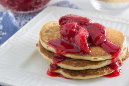 Juice laden roasted strawberries over Low FODMAP protein packed fluffy Quinoa Pancakes.
