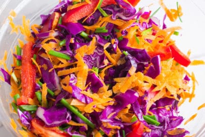 A bowl of brightly colored fresh salad vegetables.
