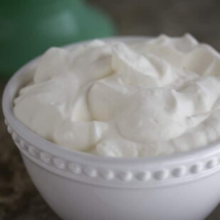 Softly whipped cream in a white bowl.
