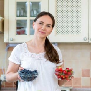 Woman with bowls of berries.