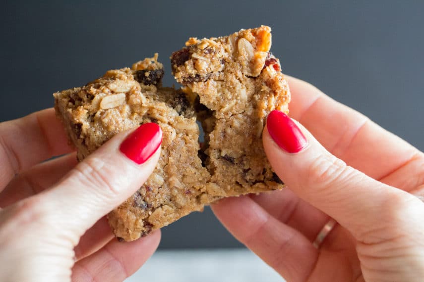 Low FODMAP soft chewy granola bars being broken into two pieces