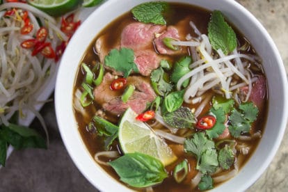 A bright bowl full of Low FODMAP Pho Bo (Vietnamese Beef Noodle Soup) - beautiful, comforting and delicious.