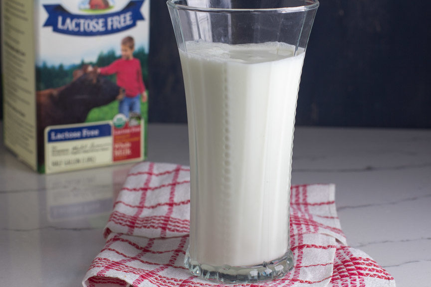 A tall glass of lactose free milk in front of Organic Valley Lactose Free Milk container