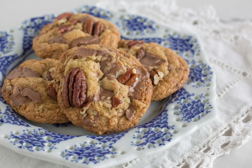 A plate of delicious gluten free milk chocolate chunk cookies with pecans.
