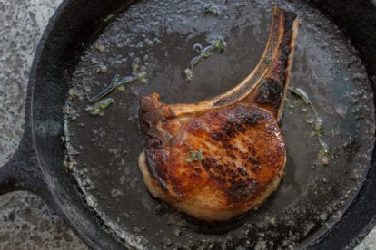 Brined Pork Chop sizzling in a pan