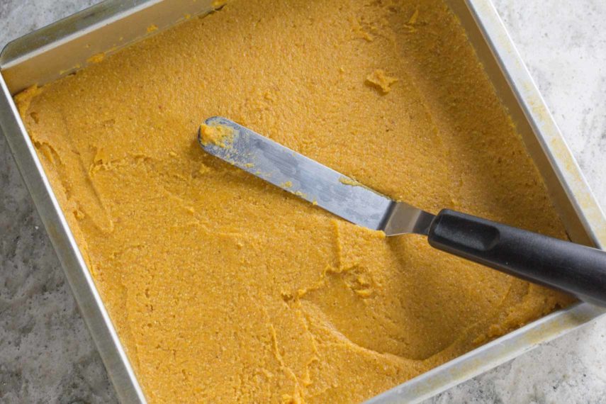 smoothing pumpkin cornbread in pan