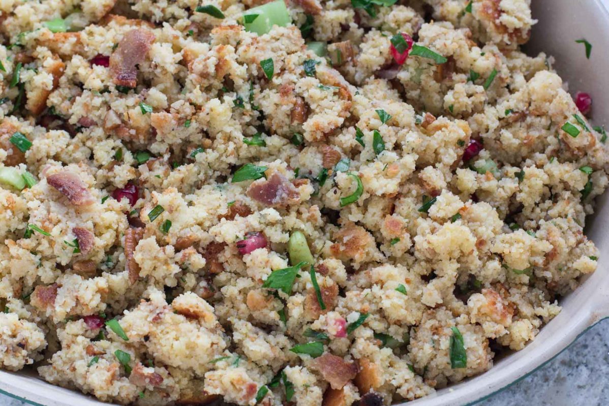 Cornbread bacon stuffing with pomegranate in an oval white casserole dish