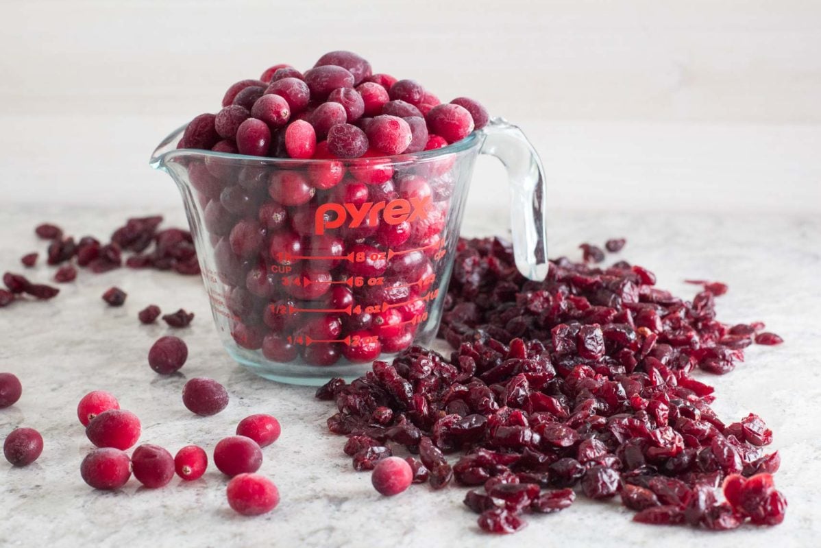 frozen cranberries in a measuring cup with dried cranberries alongside