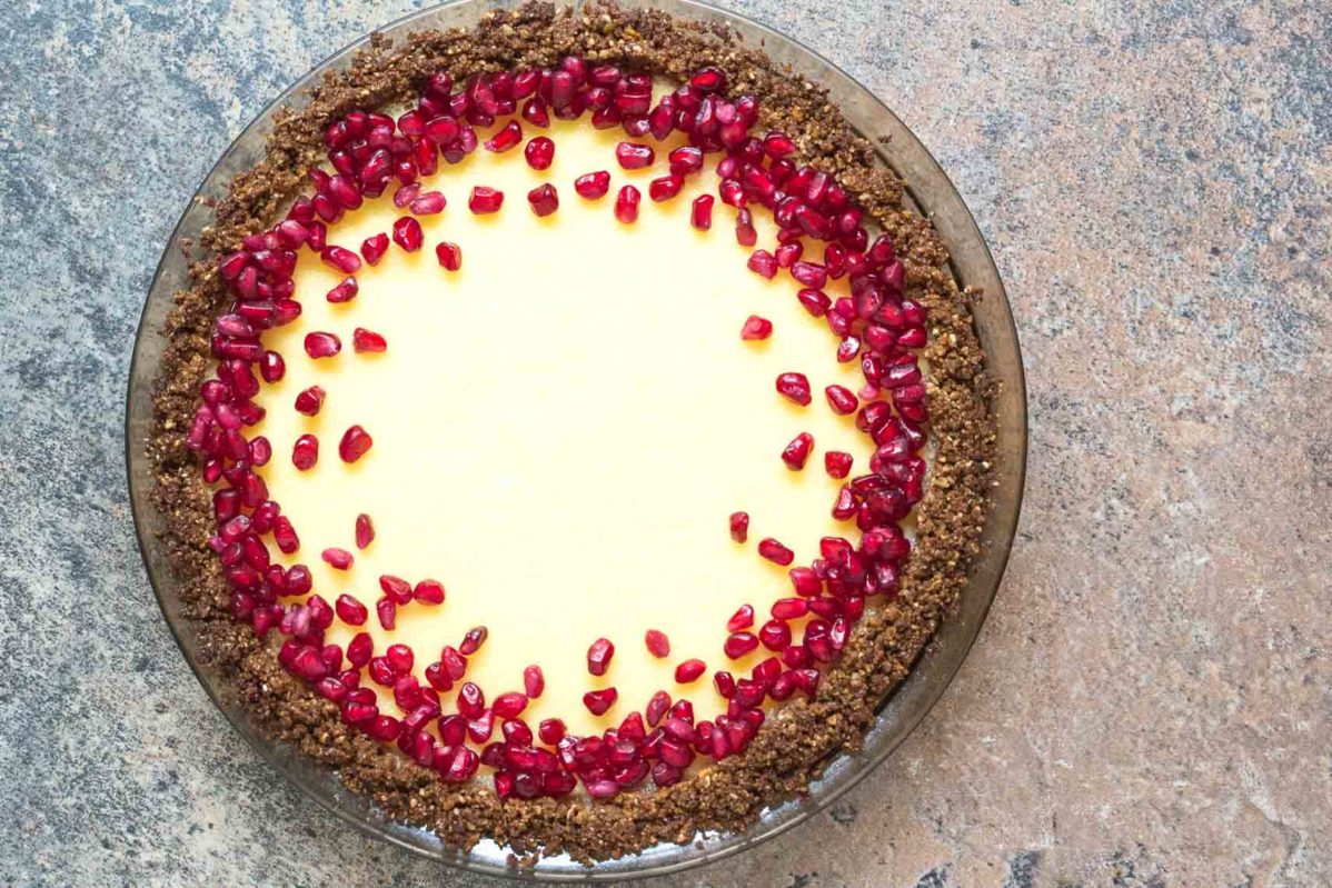 lactose free cheesecake pie in a pat-in crust topped with pomegranate_