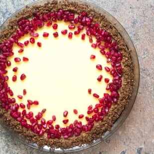 lactose free cheesecake pie in a pat-in crust topped with pomegranate_