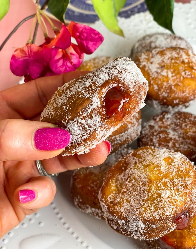 low FODMAP gluten-free jelly doughnuts held in manicured hand