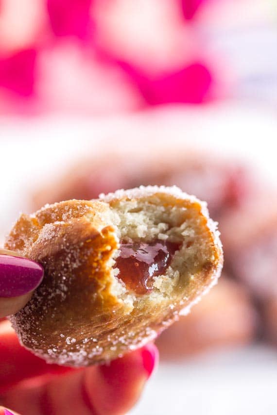 vertical closeup of jelly doughnut held in hand