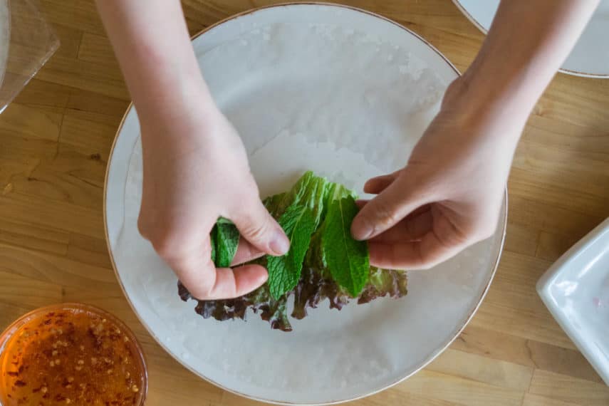 adding herbs to summer rolls