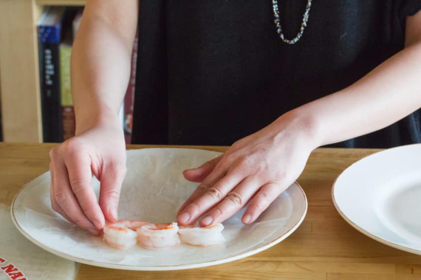 carefully placing shrimp on rice paper fo summer rolls