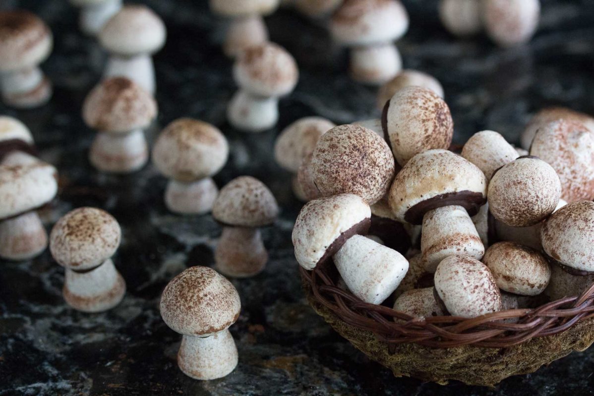 closeup of meringue mushrooms in basket. These are extra-special gluten-free Christmas cookies.