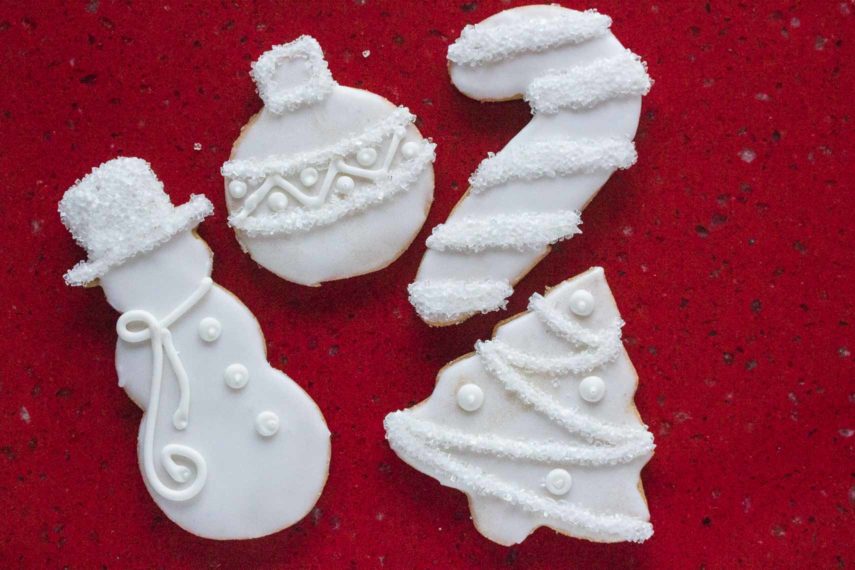 white icing decorated sugar cookies on a red background