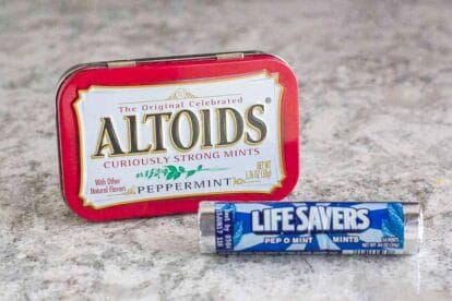 Breath mints on grey quartz counter in their packaging- Altoids and LifeSavers