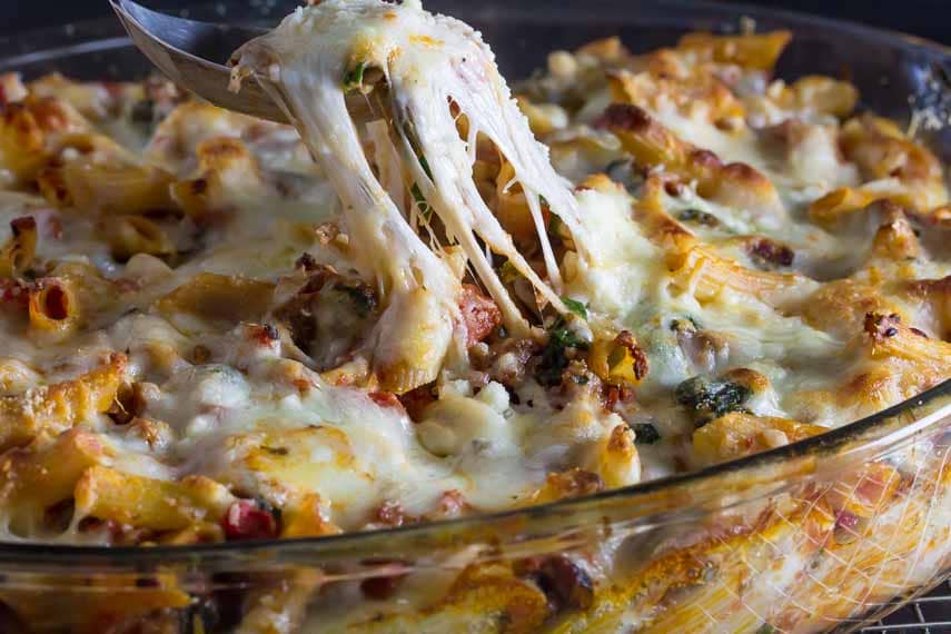 cheesy baked ziti in clear glass casserole dish