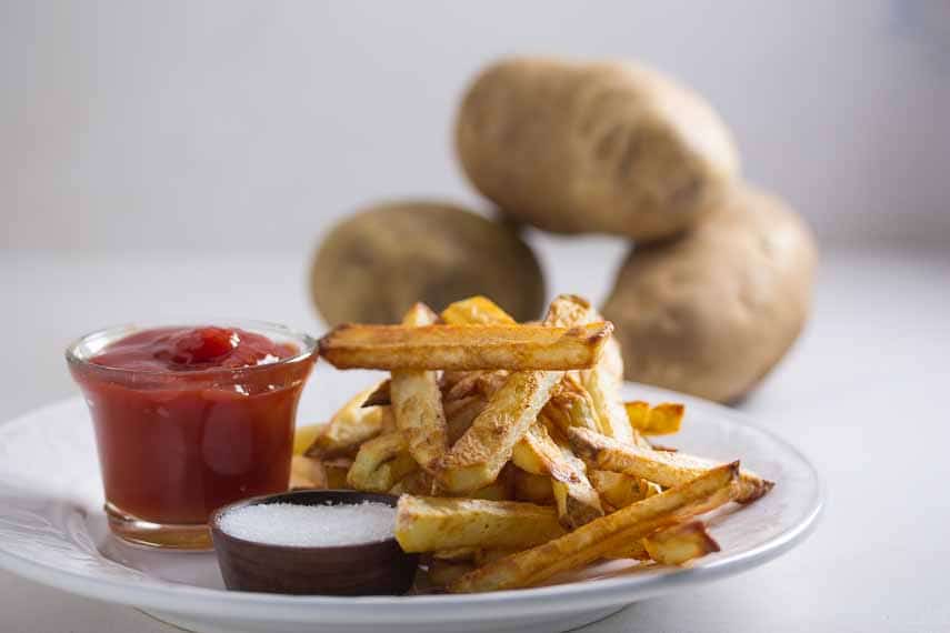 best ever oven baked fries with potatoes in background