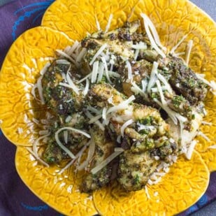 pesto chicken wings on yellow plate, overhead shot