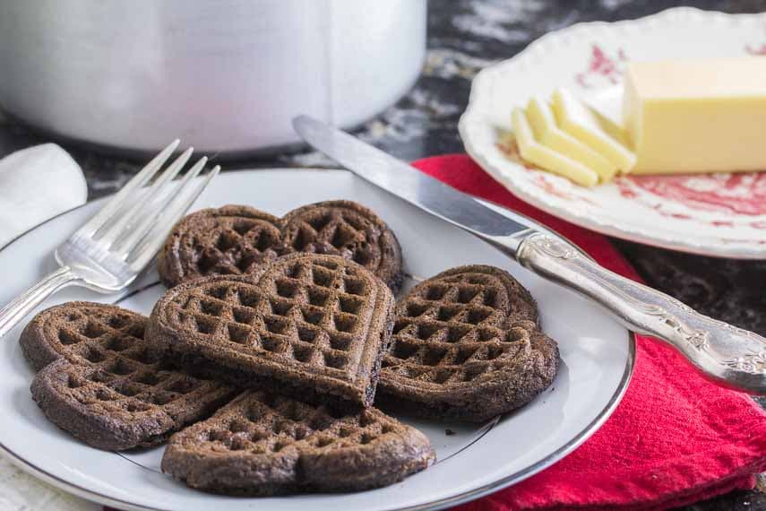 chocolate waffles in the shape of hearts on white plate