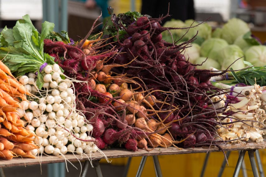 Root Vegetables stacked up on table at Farmers Market