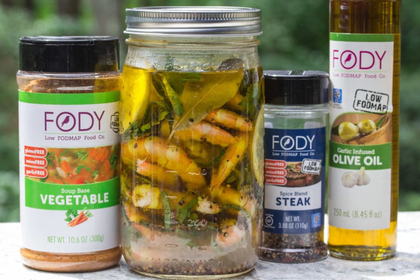 Low FODMAP Pickled Shrimp in a glass jar with ingredients alongside