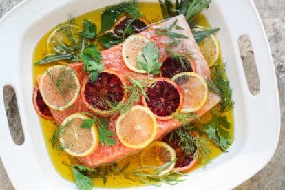 Oil Poached Salmon with fresh herbs and slices of lemon and blood orange