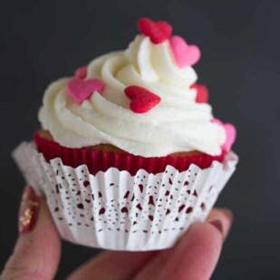 Valentine's Day cupcakes closeup held in hand with lacy paper liner