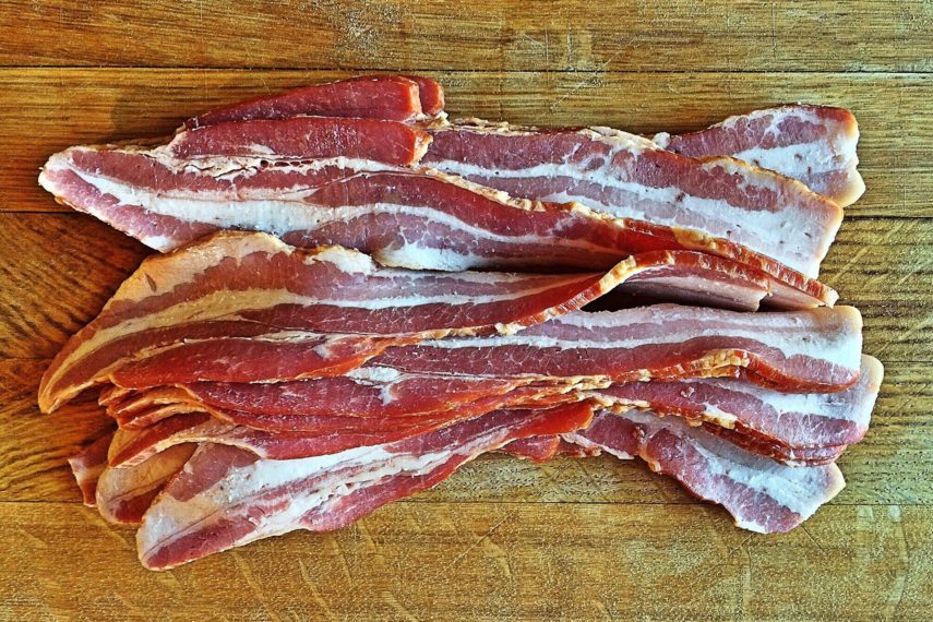 strips of meaty bacon on a wooden board