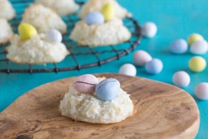 coconut macaroon nests with candy eggs inside nest on a wooden board