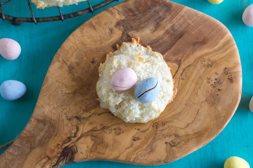 coconut macaroon nests with candy eggs, top view, on a wooden board