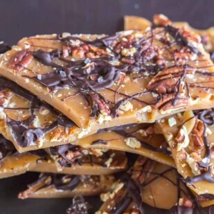 low FODMAP pecan toffee piled up against a dark background