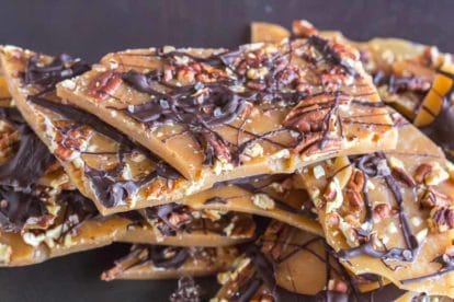 low FODMAP pecan toffee piled up against a dark background