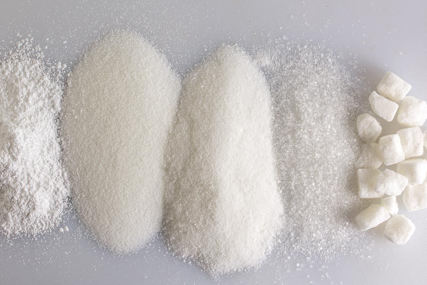 All About Sugar. 5 kinds of white sugar, overhead shot on a white board