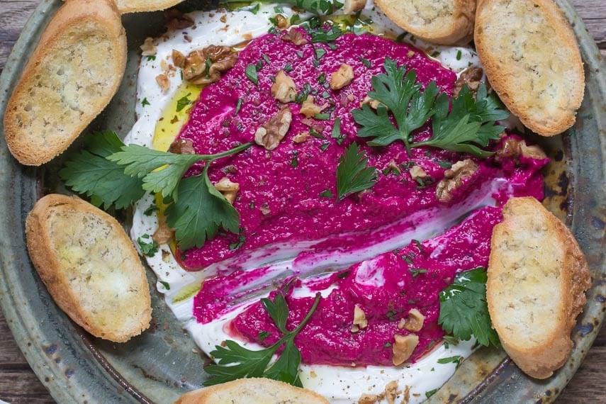 Beet Yogurt Dip with Walnuts on a rustic platter