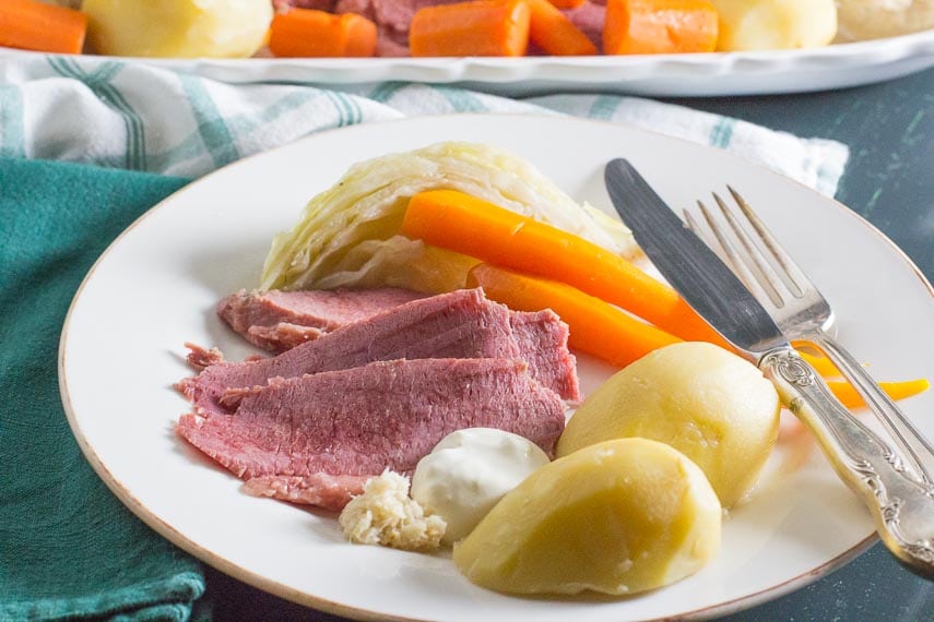 corned beef and cabbage and potatoes and carrots on a white plate