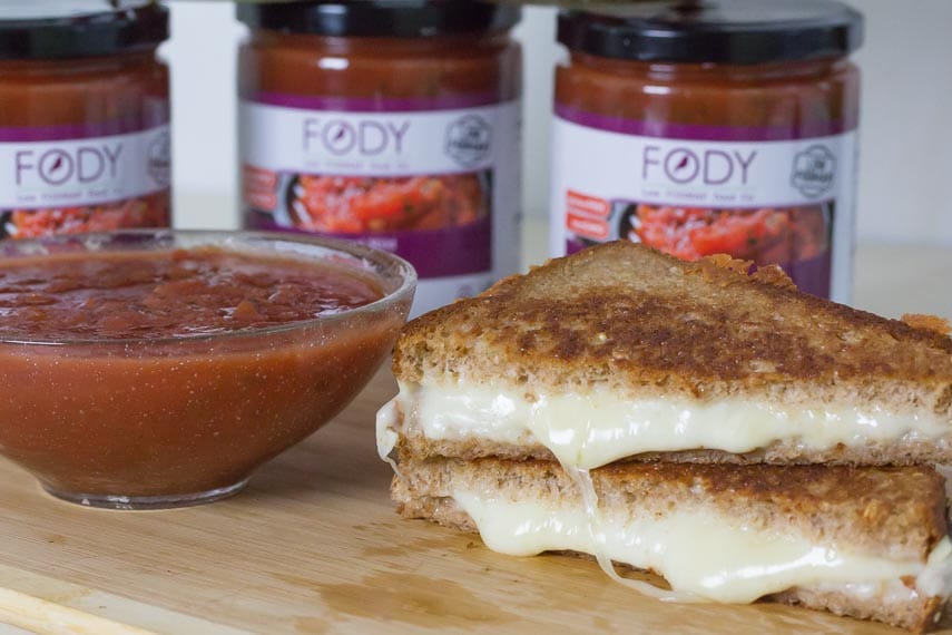 grilled cheese sandwich stacked on top of one another on a cutting board; salsa alongside