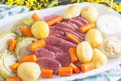 oval white platter of corned beef, cabbage, potatoes and carrots