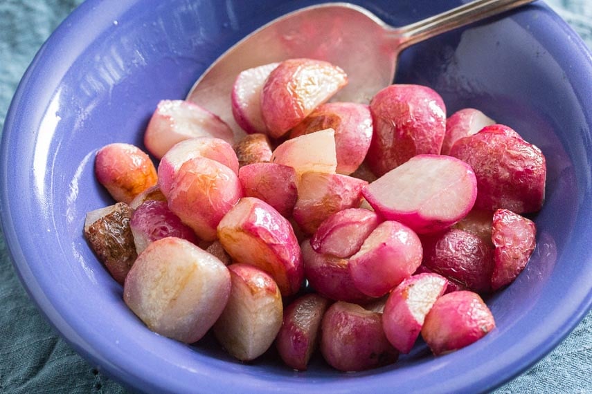 sauteed radishes in a blue bolw with a silver spoon