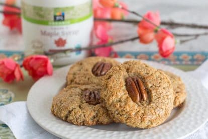 Gluten-free Maple Pecan Scones on a white plate with spring blossoms in background.