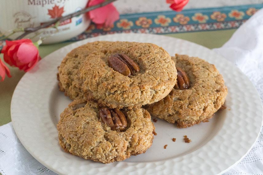 Gluten-free Maple Pecan Scones on a white plate with spring blossoms in background