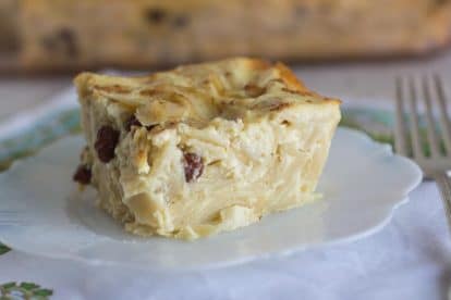 square of noodle kugel oin a white plate with a silver fork alongside