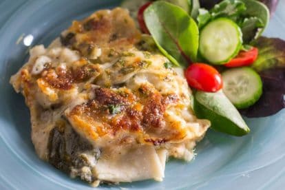 Chicken & Spinach Lasagna Bake on a blue plate with salad alongside