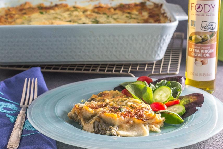 Chicken & Spinach Lasagna Bake on a blue plate with salad alongside
