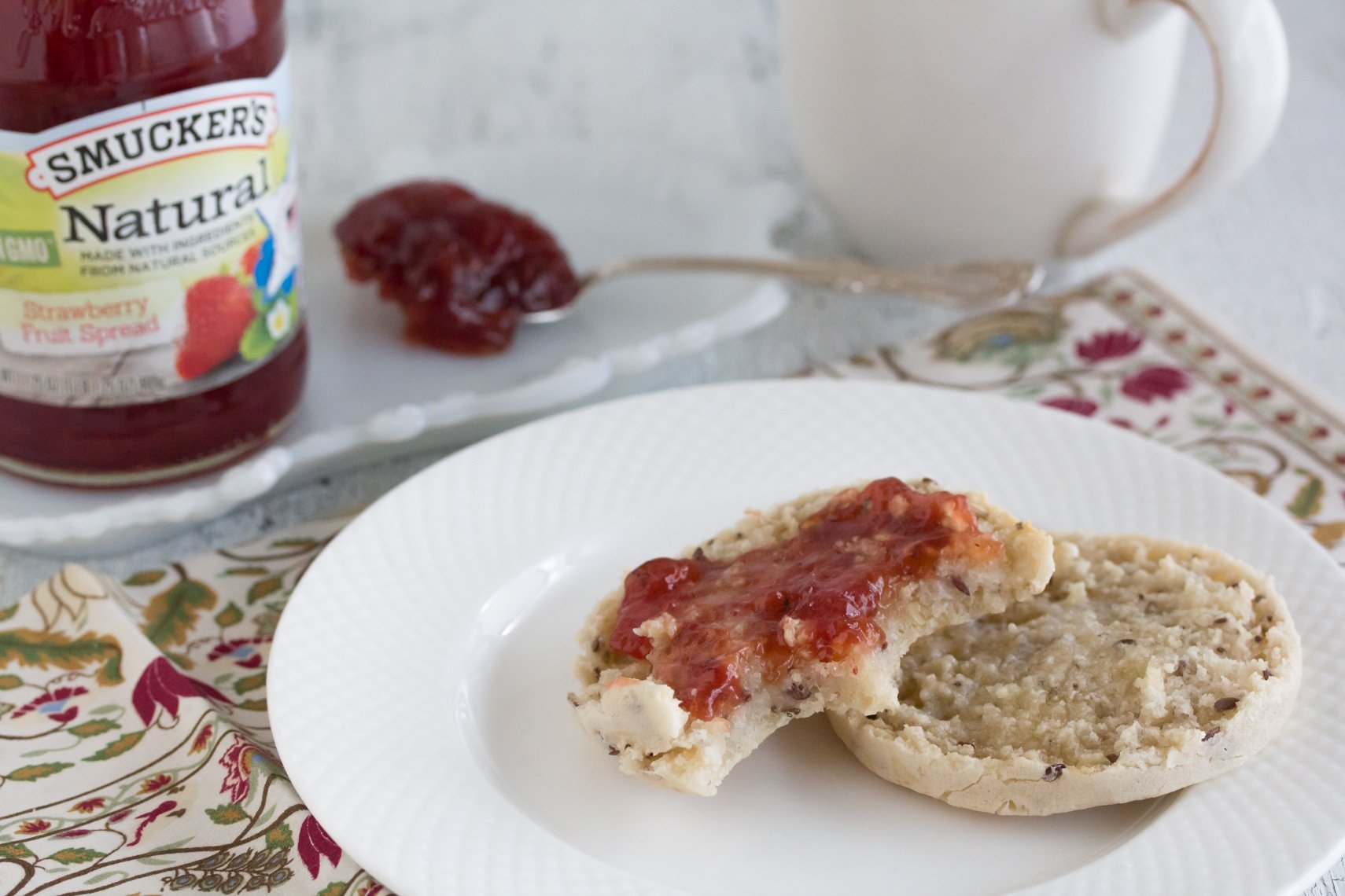 Smucker's Natural Strawberry Fruit Spread on a low FODMAP English muffin on a white plate