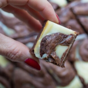 cream cheese brownies overhead image in a manicured hand