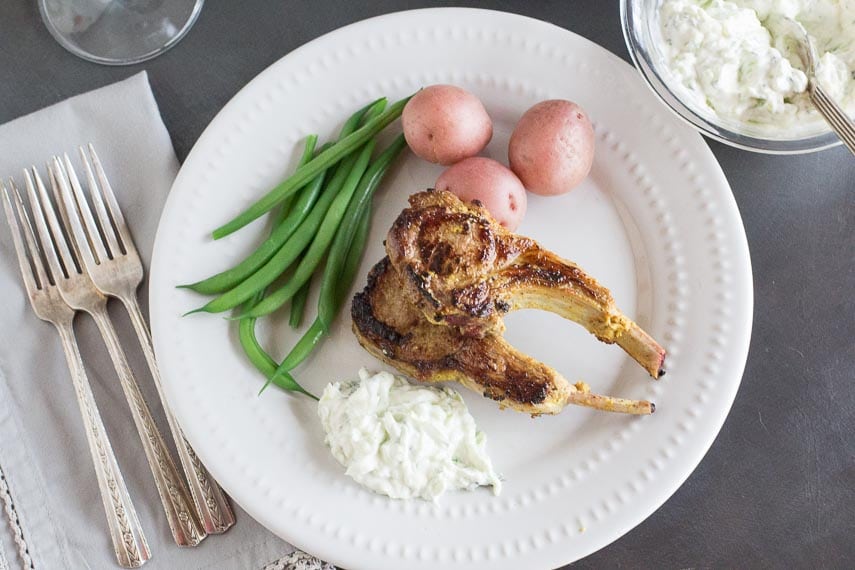 lamb chops overhead on white plate with green beans and steamed potatoes copy